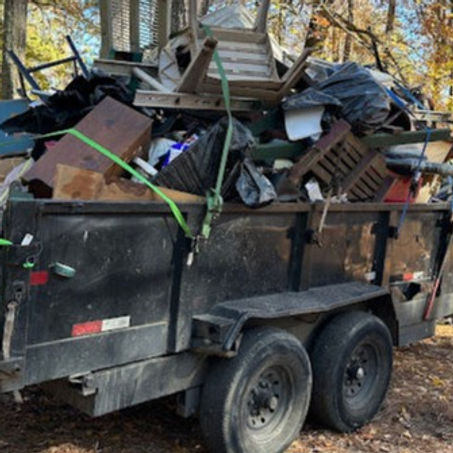 A trailer loaded with household items ready to be hauled away. - On The Spot Hauling, LLC