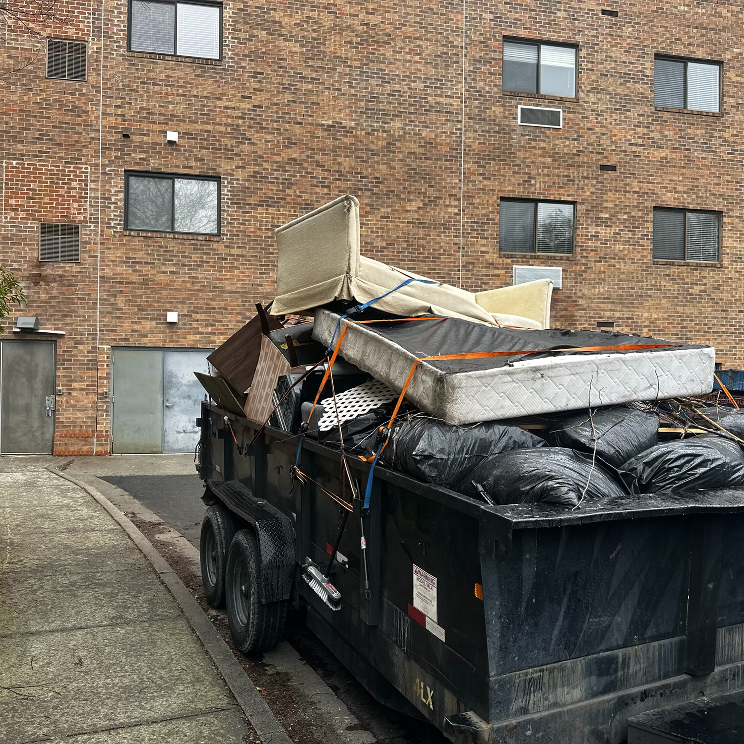 A trailer loaded with household items ready to be hauled away. - On The Spot Hauling, LLC